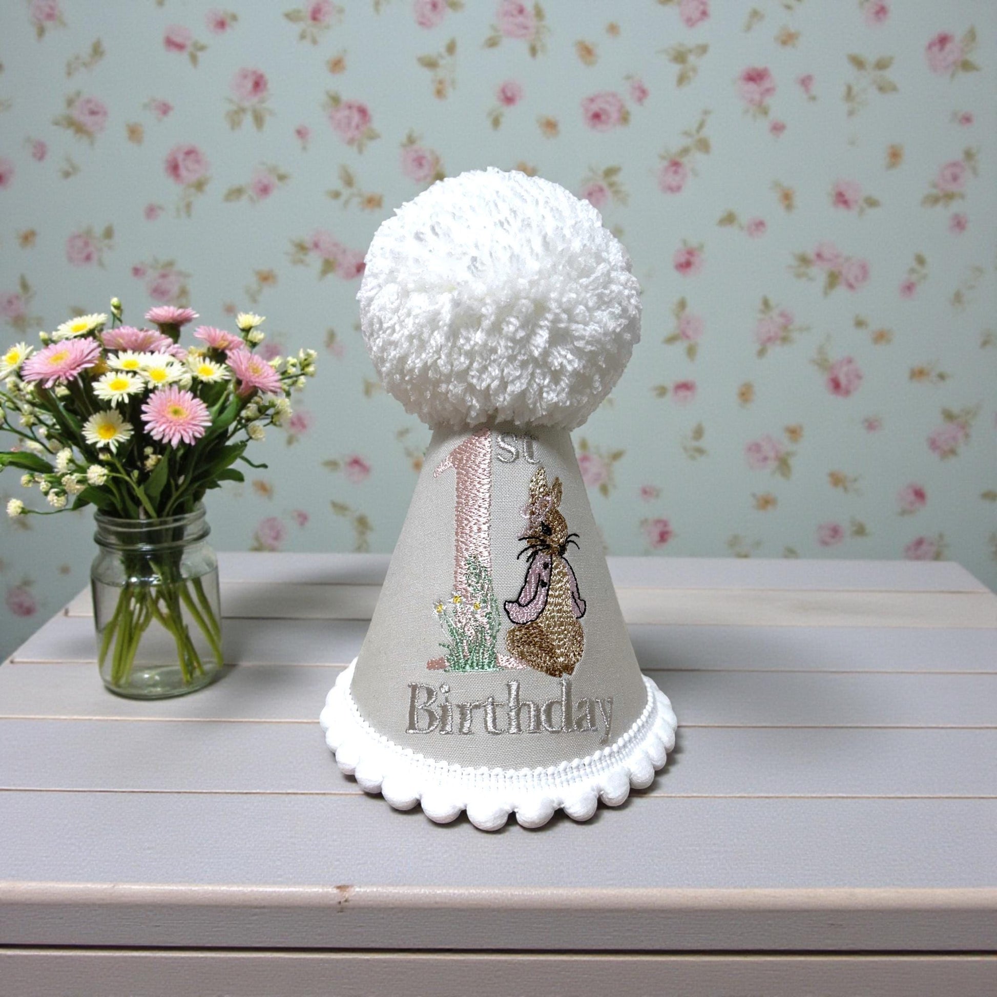 baby girls party hat - embroidered with child's birthday number. Cream base, white accents with bunny embroidery.