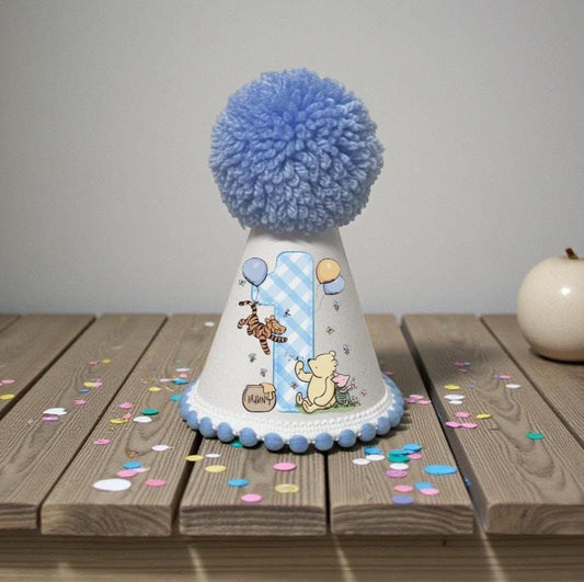 Classic honey bear first birthday party hat with blue pom pom