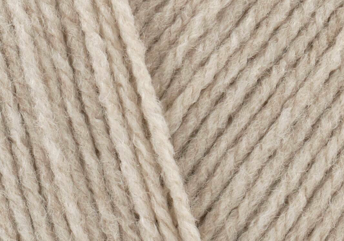 Close-up of stone-coloured yarn used to create the oversized fluffy pom-pom on the handmade birthday hat.