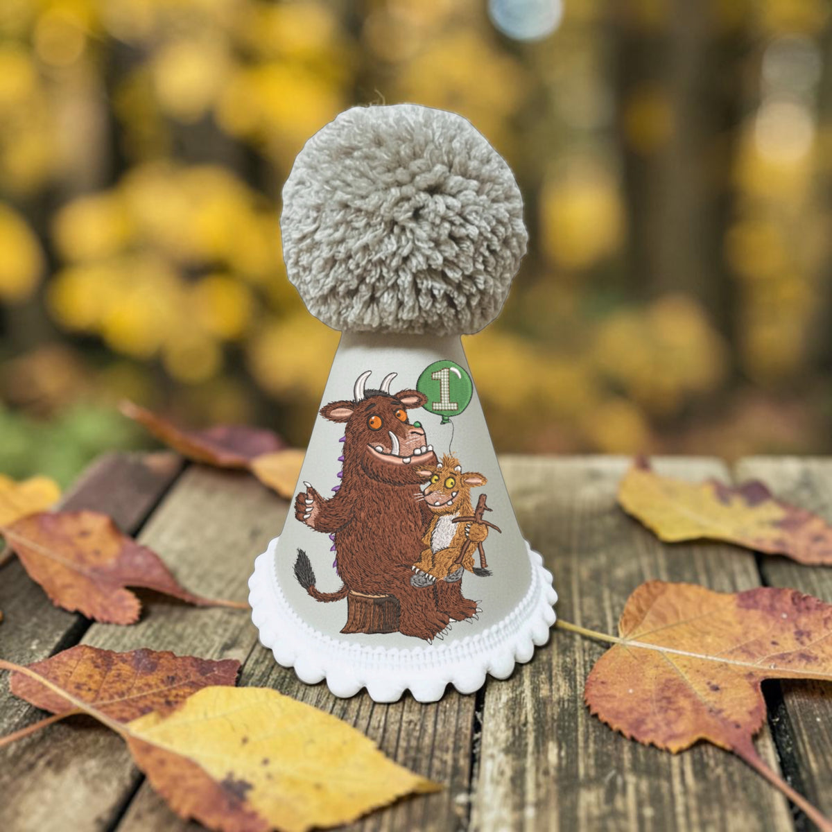 Handmade Gruffalo birthday hat with Gruffalo and Gruffalo's Child printed woodland design, green number balloon and large yarn pom-pom.