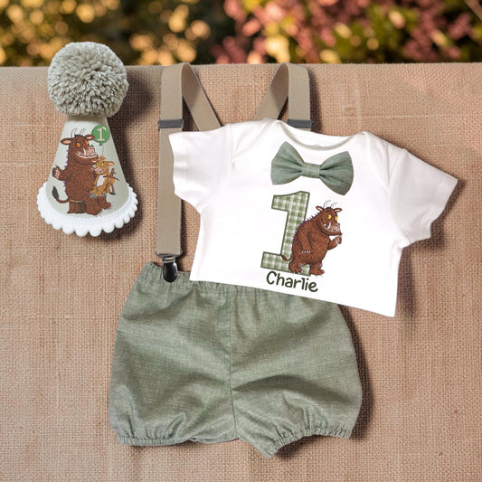 Personalised Gruffalo baby boy first birthday outfit with printed white bodysuit, sage green gingham number, handmade sage bloomers, matching bow, beige braces and Gruffalo party hat.