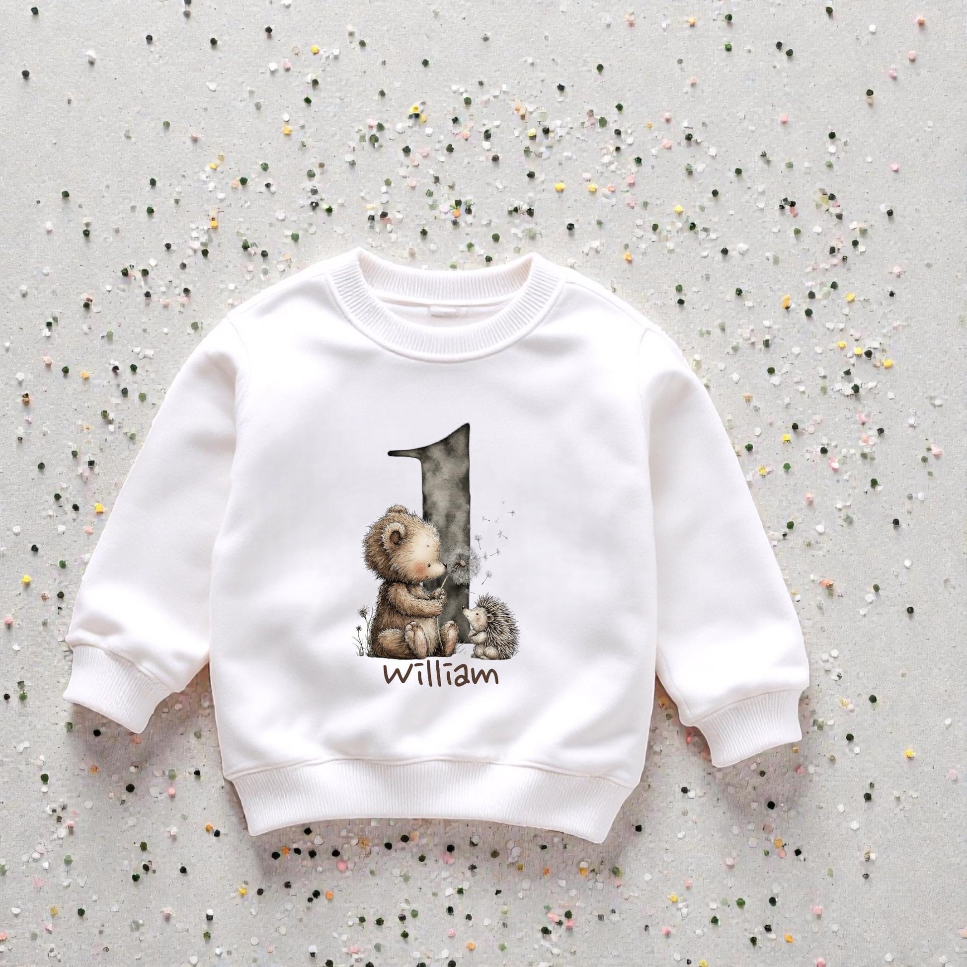 Personalised woodland birthday sweatshirt laid flat showing soft watercolour animal artwork