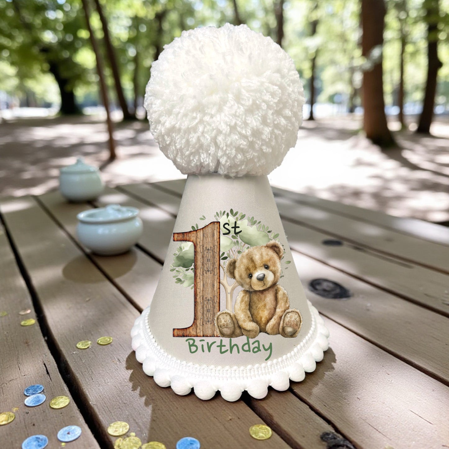 Woodland teddy bear printed birthday outfit with fluffy pompom hat, perfect for cake smash and milestone photos.