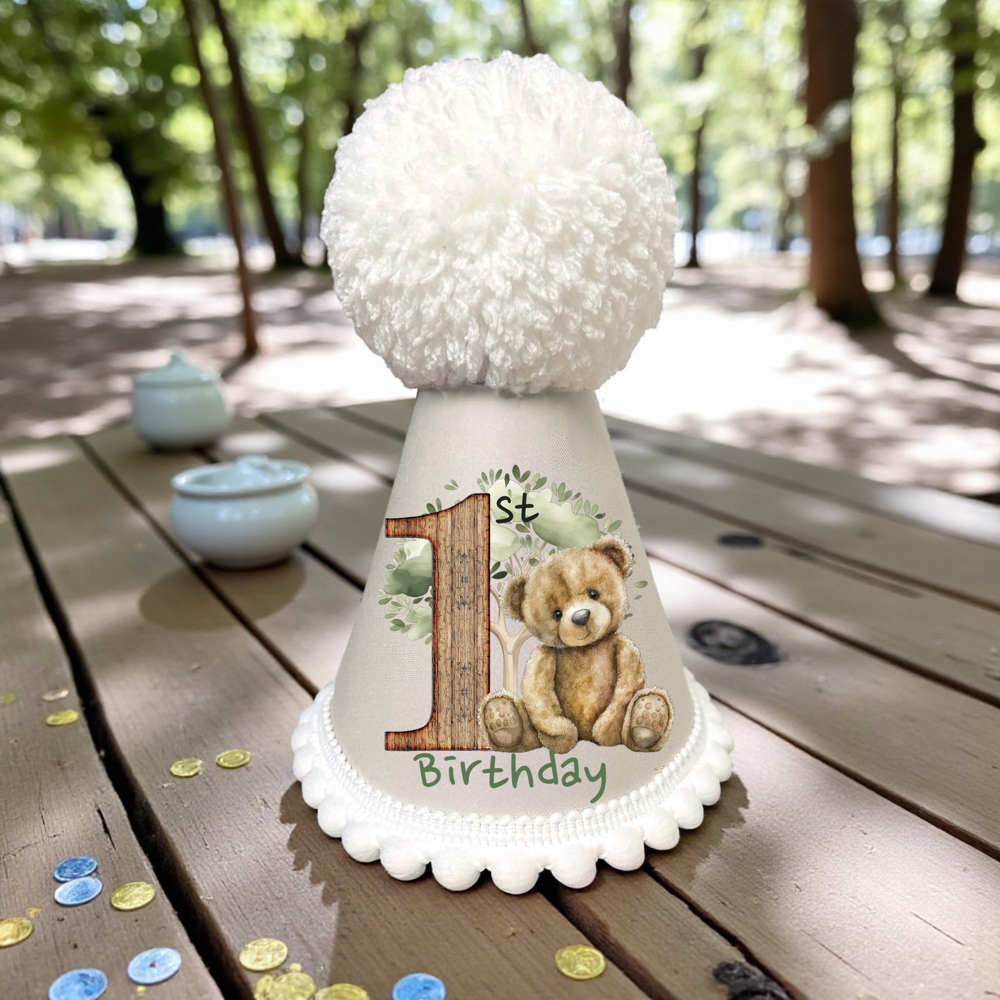 Woodland teddy bear printed birthday outfit with fluffy pompom hat, perfect for cake smash and milestone photos.