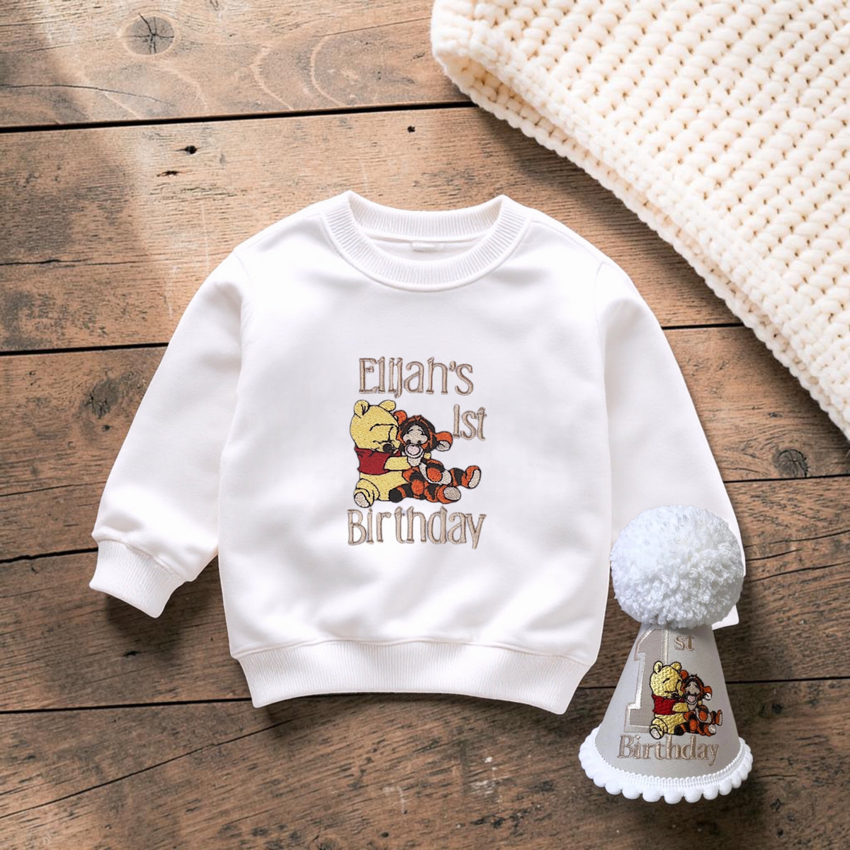 a wh9ite embroidered sweatshirt featuring a Baby Pooh Bear and Tigger.